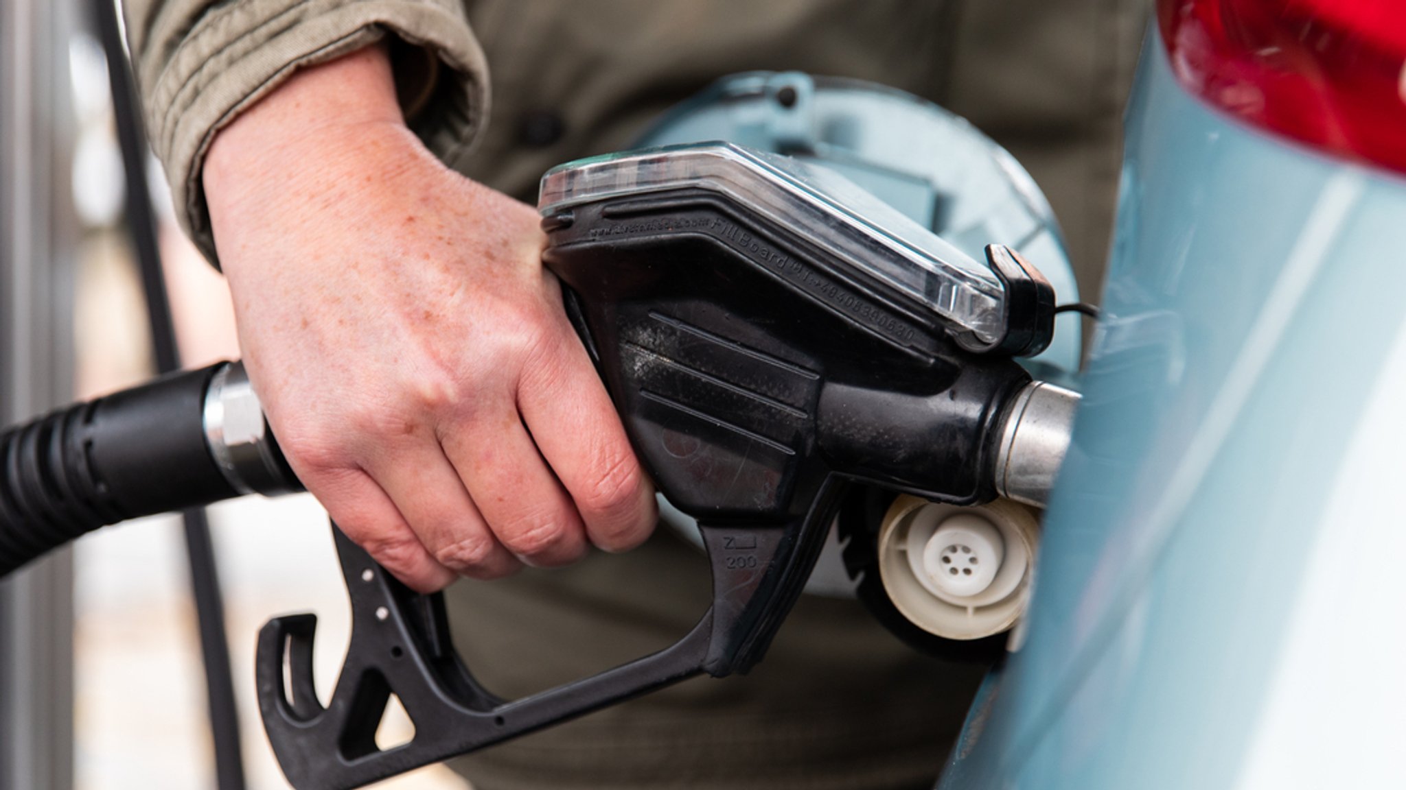 Eine Frau tankt ihr Auto an einer Tankstelle auf.